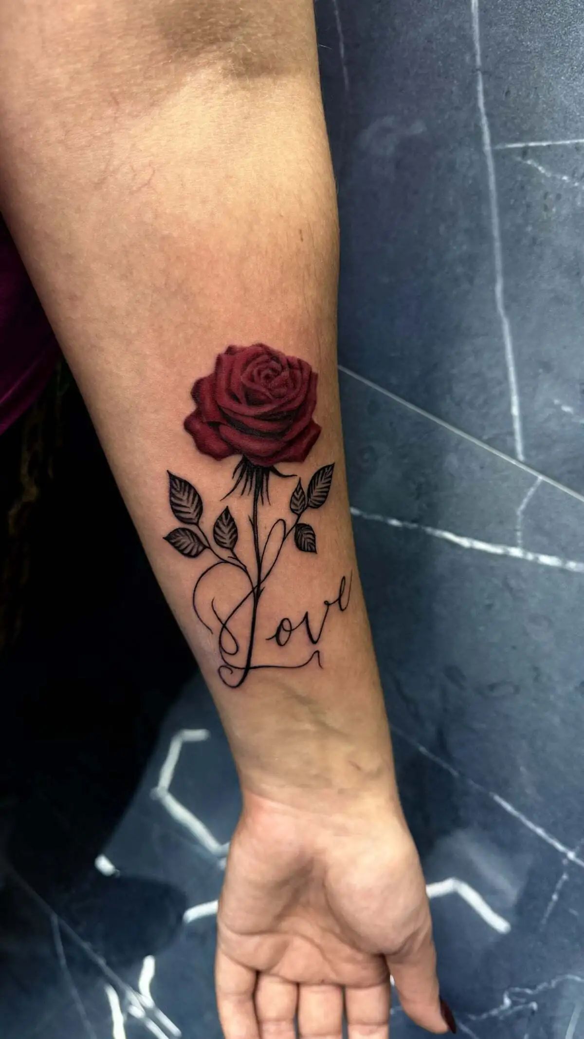 red rose script love forearm tattoo