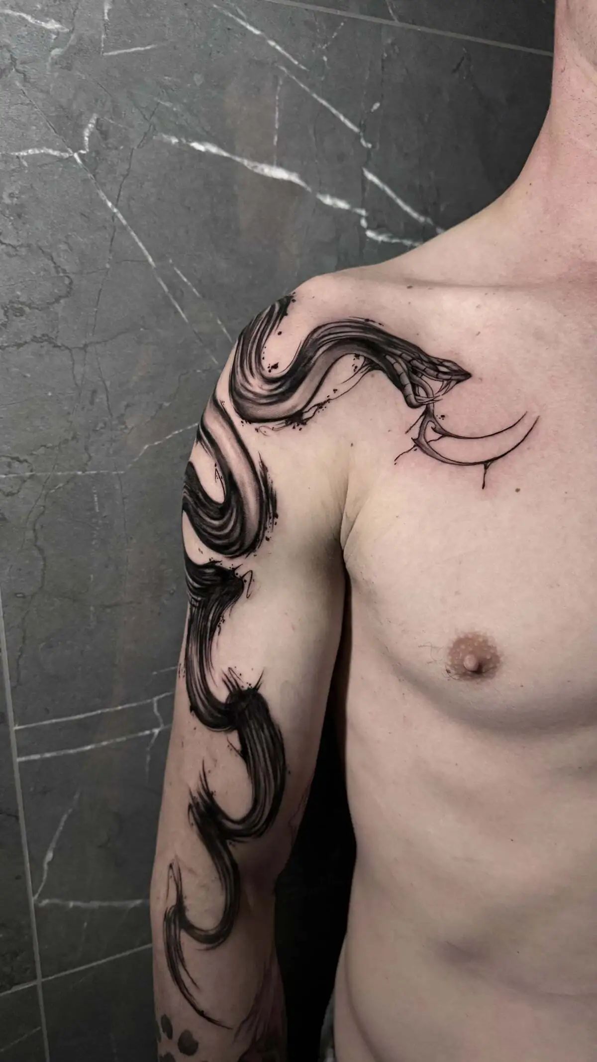 abstract dark brush stroke snake shoulder arm tattoo