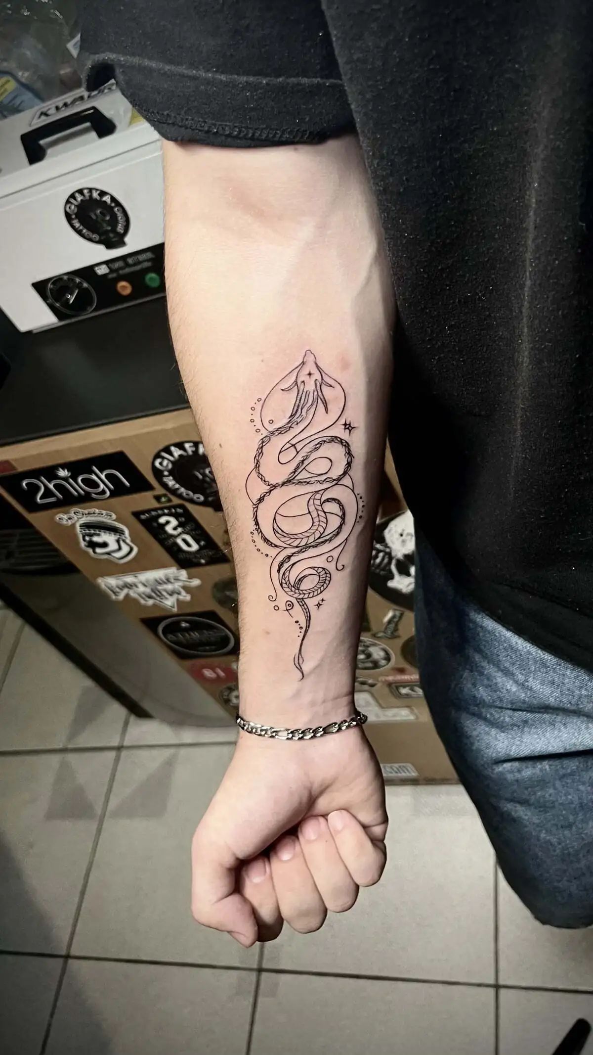 minimal snake fine line forearm tattoo
