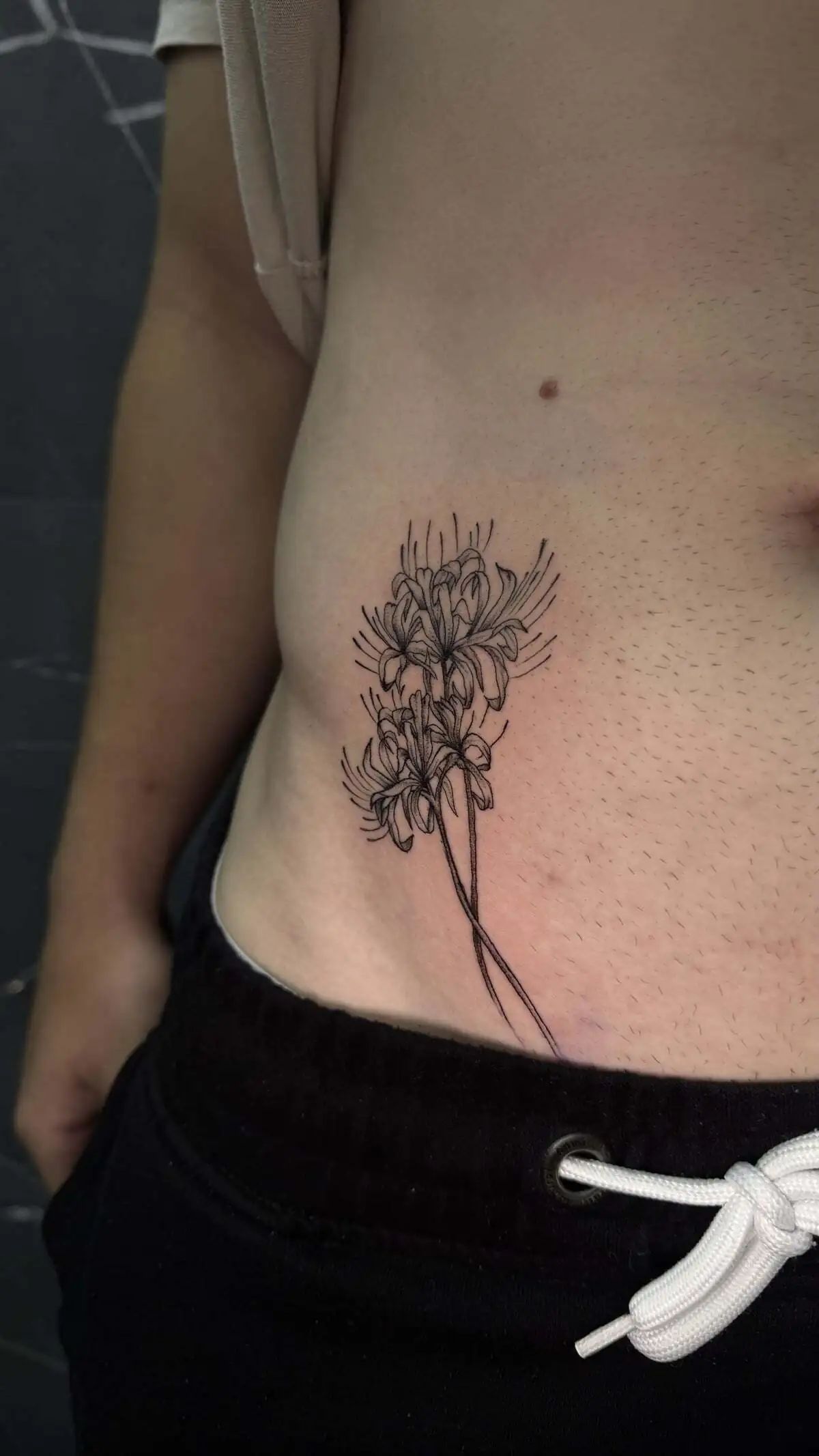 fine line floral branch side torso tattoo