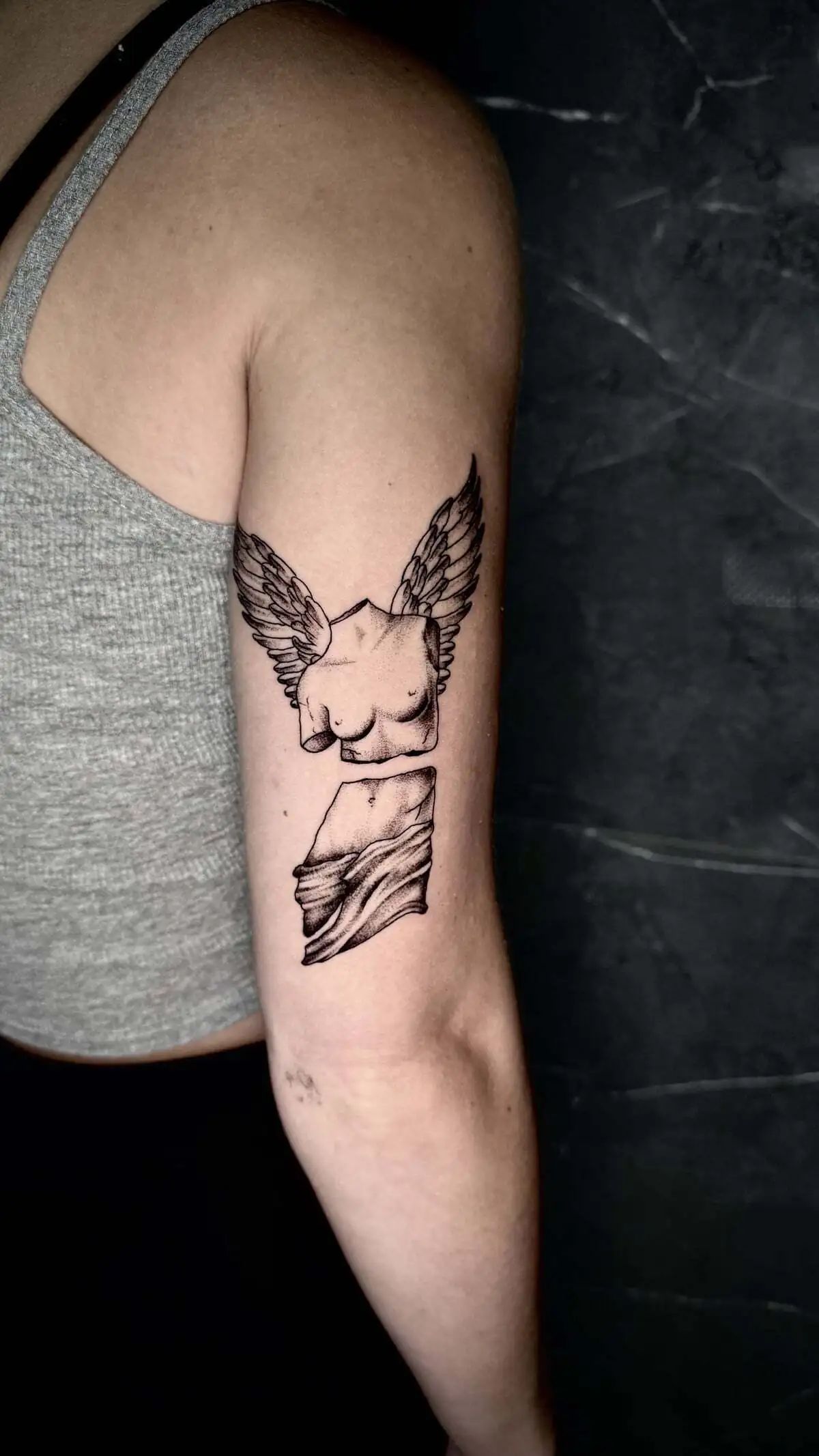 winged broken statue torso micro realism arm tattoo