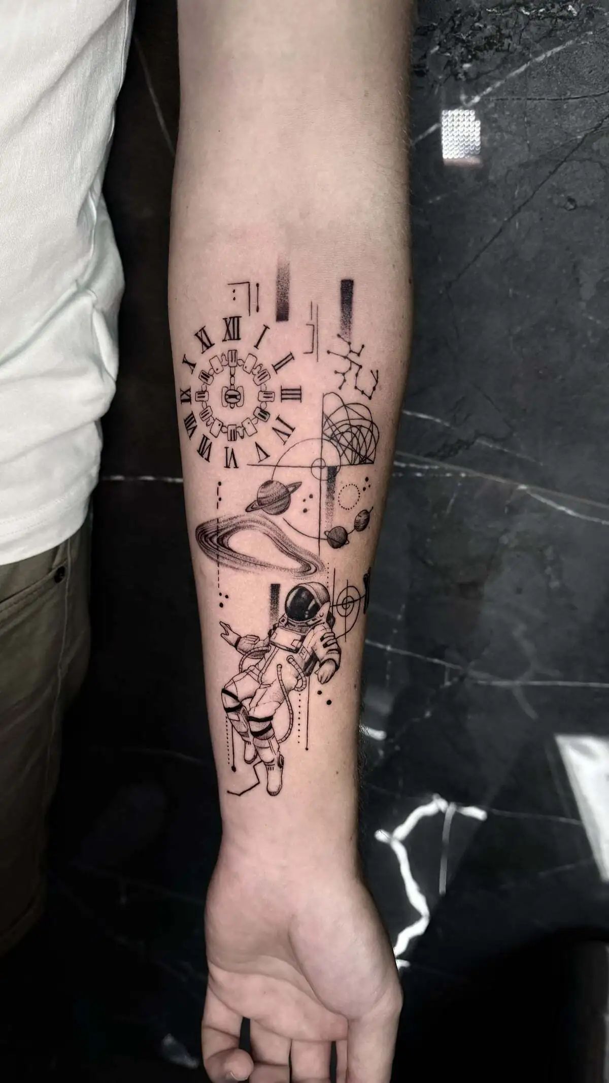 astronaut planets geometric micro realism forearm tattoo